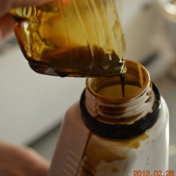 Low Viscosity Rubber Process Oil (RPO) being poured for testing — high-purity paraffinic oil used in tire, rubber, and compound manufacturing by Basekim.